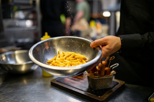 chef preparing french fries in kitchen