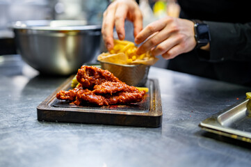 chef cookind chicken breast strips and french fries on restaurant kitchen