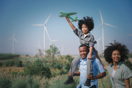 African american family in the community with wind generators turbines, Wind turbines are alternative electricity sources, the concept of sustainable resources and Renewable energy. wind turbines farm