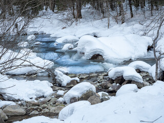 Beautiful winter panorama with fresh powder snow. Landscape with fir trees, blue sky with sunlight and high alpine mountains in the background The beautiful winter landscape with trees covered with ho