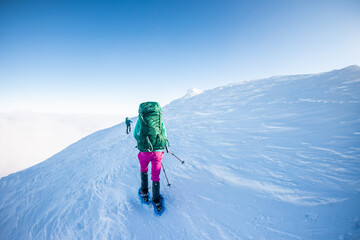 Fototapeta na wymiar climbers climb to the top of the mountain in winter