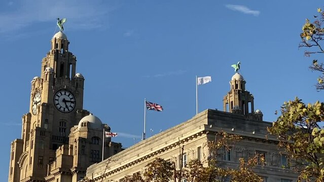 Liverpool, UK: The Royal Liver Building. Famous Pier Head building with clock and Liver Birds guarding city and the sea. Cunard Building, Two of the three graces. St George Cross and Union Jack
