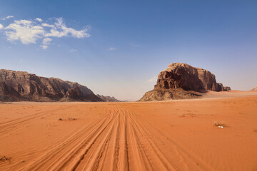 Fototapeta na wymiar tire tracks in the red sand of jordanian desert wadi rum