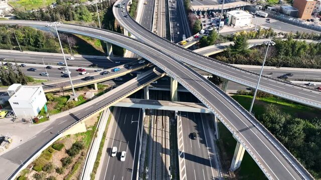 Aerial drone rotational video of modern multilevel junction with crossing bridges, passing through National road of Athens and Attiki odos motorway