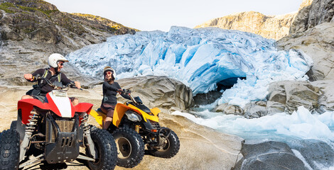 ATV Quad driving people - happy smiling couple in front of Glacier.