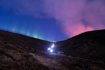 Hiker headlamps starburst volcano aurora