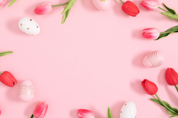 Obraz na płótnie Canvas Easter holiday flower composition. Easter eggs and tulip flowers on an isolated pastel pink background. Easter concept. Flat lay, top view, copy space