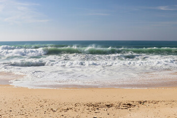 Water spraying off waves in the Atlantic ocean on a warm winter day at a beach near Lisbon, Portugal.