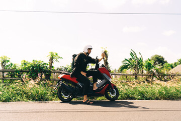Man on motorcycle taking selfie in Bali
