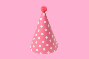 Bright and colorful birthday cap isolated on a pink background.
