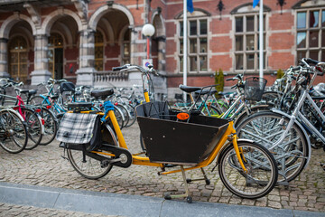 Fototapeta na wymiar Pretty yellow cargo bike on the street of Groningen, Netherlands