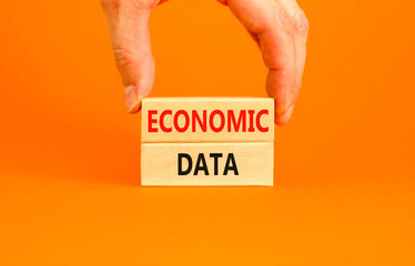 Economic data symbol. Concept words Economic data on wooden block. Beautiful orange table orange background. Businessman hand. Business economic data concept. Copy space.