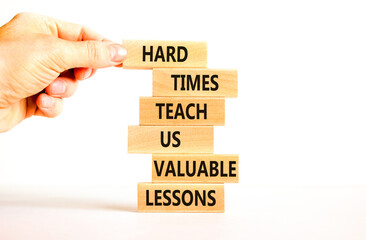 Lesson from hard times symbol. Concept words Hard times teach us valuable lessons on wooden blocks on a beautiful white background. Businessman hand. Business lesson from hard times concept.