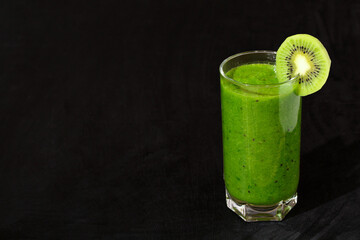 smoothie, a thick green drink with kiwi on a black background.