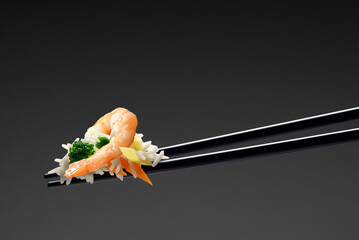 Basmati rice with shrimp and vegetables on chopsticks