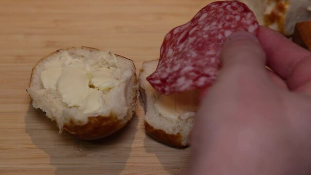 A piece of salami is placed on a lye bread smeared with butter.