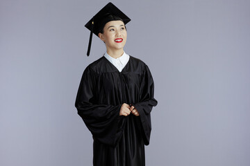 smiling graduate student asian woman isolated on gray