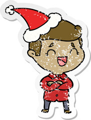 distressed sticker cartoon of a laughing man wearing santa hat