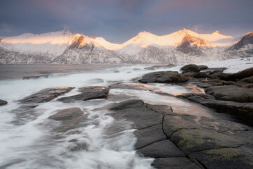 Snow covered mountain range on coastline in winter, Norway. Senja panoramic aerial view landscape nordic snow cold winter norway ocean cloudy sky snowy mountains. Troms county, Fjordgard 