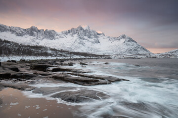 Snow covered mountain range on coastline in winter, Norway. Senja panoramic aerial view landscape nordic snow cold winter norway ocean cloudy sky snowy mountains. Troms county, Fjordgard 