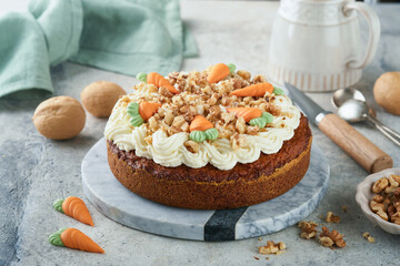 Easter Carrot cake with cream cheese frosting. Delicious carrot cake with walnut and cream cheese frosting on gray concrete background table for festive dinner. Traditional carrot cake. Easter food.
