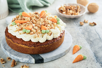 Easter Carrot cake with cream cheese frosting. Delicious carrot cake with walnut and cream cheese frosting on gray concrete background table for festive dinner. Traditional carrot cake. Easter food.