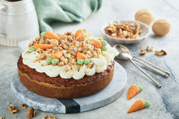 Easter Carrot cake with cream cheese frosting. Delicious carrot cake with walnut and cream cheese frosting on gray concrete background table for festive dinner. Traditional carrot cake. Easter food.