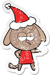 distressed sticker cartoon of a bored dog wearing santa hat
