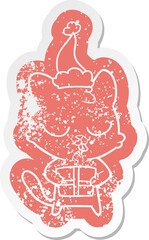 cute cartoon distressed sticker of a cat wearing santa hat