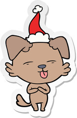 sticker cartoon of a dog sticking out tongue wearing santa hat