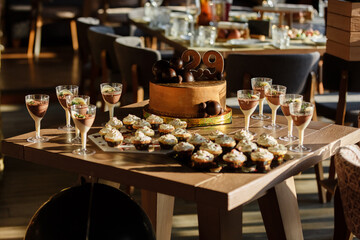 Candy Bar. Delicious sweet buffet with brown birthday cake decorated chocolate balls and number 29, cupcakes with white milk cream, mousse desserts . Birthday party at restaurant