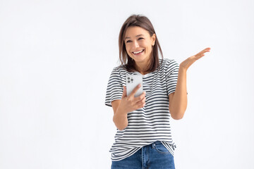 Enthusiastic smiling Caucasian woman holding mobile phone received good unexpected news standing on a white background, emotional facial expression