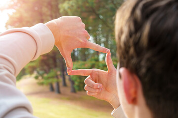 Young man framing beautiful nature with fingers