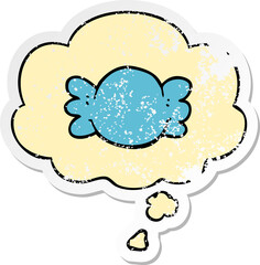 cartoon wrapped candy and thought bubble as a distressed worn sticker