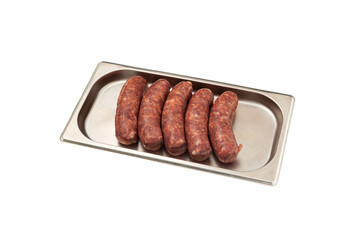 Five raw sausages for barbecue grill on metal tray. Natural meat processed foods. Frankfurters. White background. Selective focus, copy space