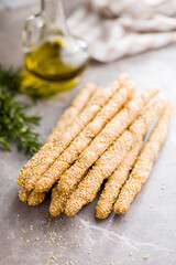 Italian grissini bread sticks with sesame seeds on kitchen table.