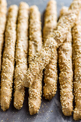 Italian grissini bread sticks with sesame seeds on kitchen table.