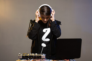 Female DJ on a mixer. Girl playing texhno music against gray background.