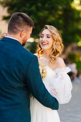 Fototapeta premium a bride in a delicate dress with a bouquet with the groom in the park