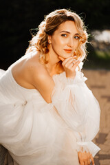 Fototapeta na wymiar portrait of a beautiful blonde bride in a white dress at sunset