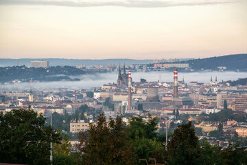Brno, Czech Republic - Panorama of the city and houses in the clouds at sunrise.