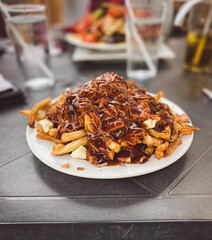 Poutine with gravy and cheese curds on a plate at a restaurant in Ontario, Canada.
