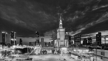 Evening cityscape with city lights, in black and white color - view of the Warsaw downtown and The Palace of Culture and Science. Warsaw. Poland