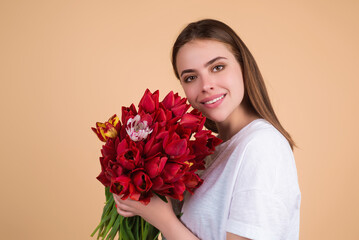 Beauty girl with tulip. Beautiful sensual woman hold bouquet of tulips, studio portrait on beige background.