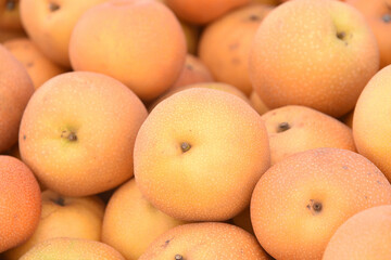 Close up top view of super sweet Asian Pears piled up for sale at Farmers Market