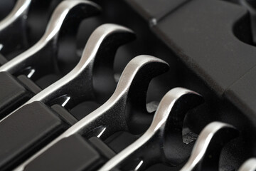 Wrenches lying in a row in a toolbox.