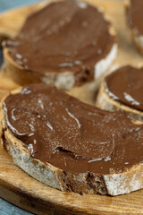 Chocolate cream on the sliced bread above blue background