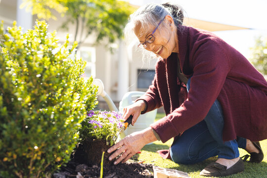 Happy senior asian woman gardening and replanting flowers
