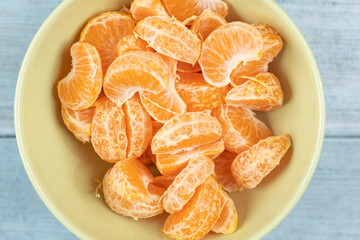 Tangerines in the bowl above dark blue food backgrounds