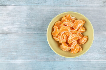 Tangerines in the bowl above dark blue food backgrounds